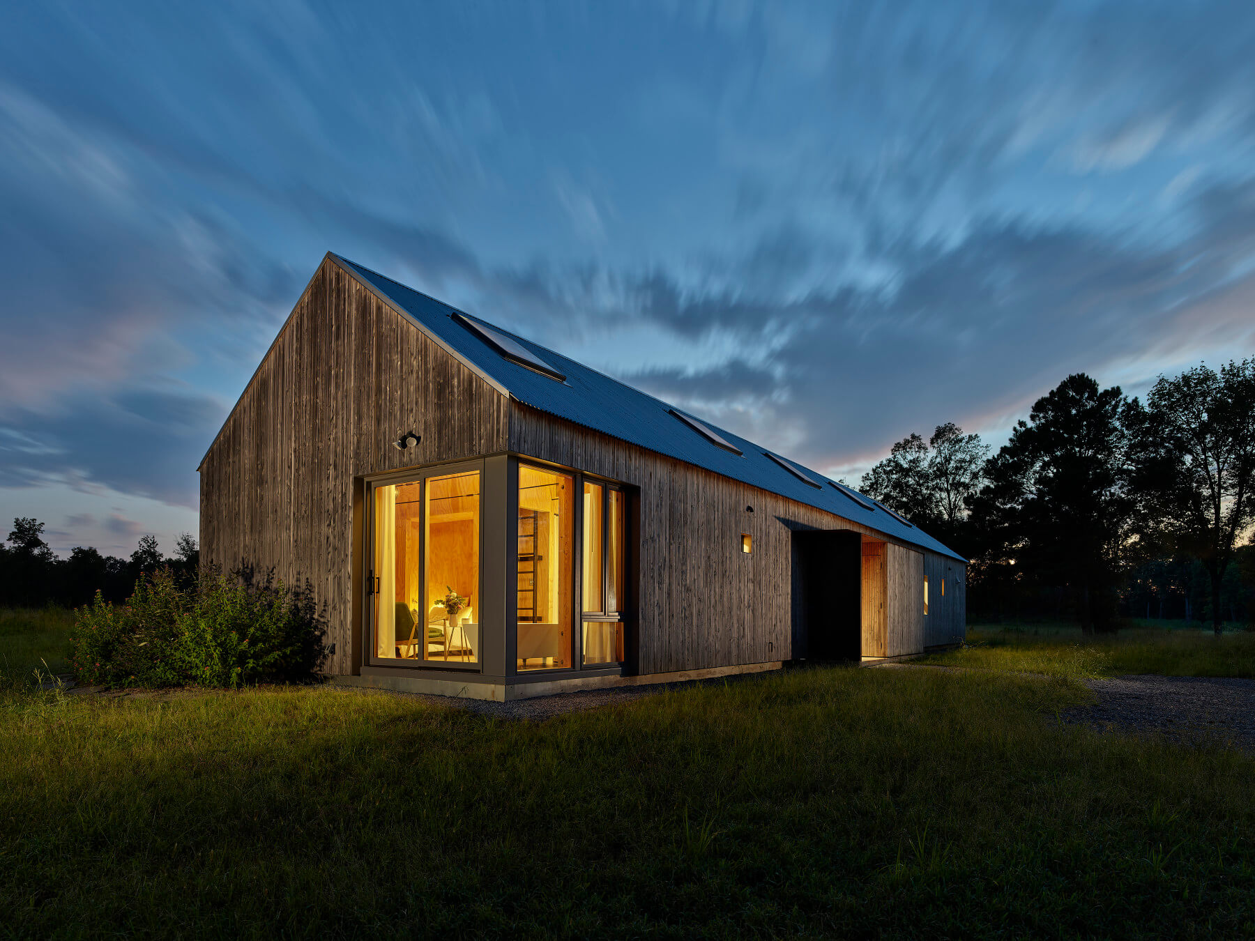 Exterior of home at dusk with light emanating from windows.